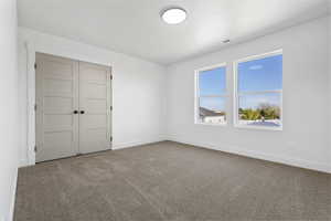 Empty room with carpet floors and baseboards