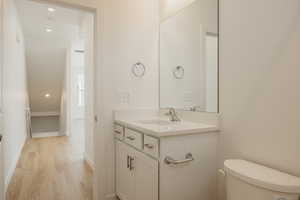Bathroom with recessed lighting, vanity, and light wood-style flooring