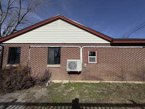 Side of home with AC/Heating Unit for both rooms on this side of the home for controlled climate control, with brick siding.