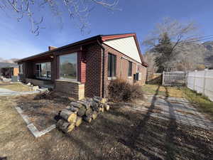 Side Yard, View of home's exterior with brick siding, a fenced backyard, a chimney.