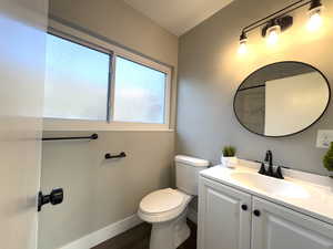 Full bath with tub and shower, vanity, upgraded toilet and dark wood-style flooring