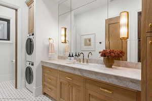 Bathroom featuring vanity and stacked washer / drying machine