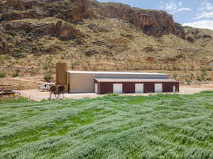 View of pole building with a lawn, a mountain view, and a view of rural / pastoral area