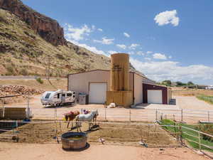 View of front facade featuring an outdoor structure, a detached garage, a view of rural / pastoral area, and a mountain view
