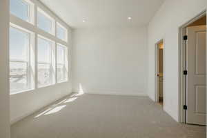 Spare room featuring light colored carpet and recessed lighting