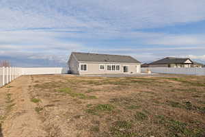 Rear view of house featuring a fenced backyard and a patio area