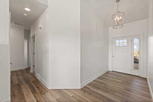 Entryway featuring LVP flooring, light paint, and high ceilings