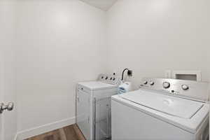 Laundry area with LVP floors, light paint, and washer and dryer