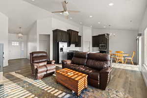 Open concept living area featuring LVP flooring, vaulted ceilings, and natural light