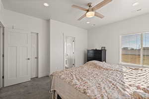 Primary bedroom featuring carpeted floors, ceiling fan, and natural light