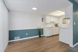 Kitchen has been updated with new countertops, white cabinetry, and new light fixtures.