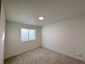 Unfurnished room with a textured ceiling and light carpet