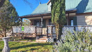 Entrance to property featuring a metal roof and a yard