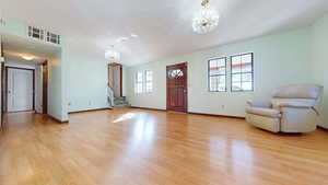 Foyer entrance with a chandelier and light wood-type flooring