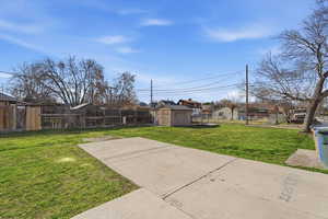 Fenced backyard with a shed and a residential view