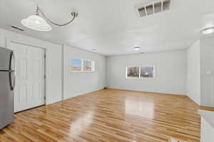 Spare room featuring light wood-type flooring and baseboards