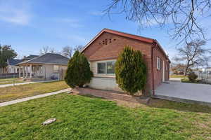 View of side of property featuring brick siding and a porch