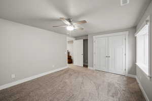Unfurnished bedroom featuring carpet floors, a closet, and a ceiling fan