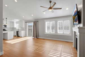 Unfurnished living room featuring lofted ceiling, a fireplace, ceiling fan, light wood finished floors, and recessed lighting