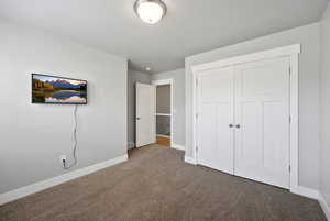 Unfurnished bedroom with carpet flooring and a closet