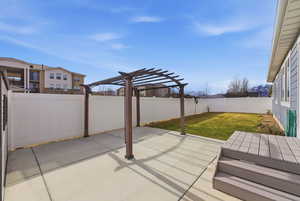 Fenced backyard featuring a patio area and a pergola, view of Timp.