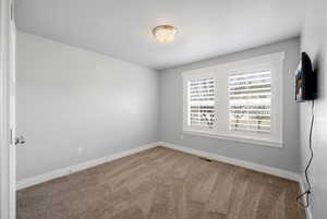 Empty room with baseboards and carpet