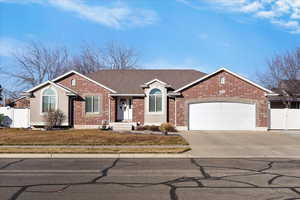 Ranch-style house featuring a gate, concrete driveway, a shingled roof, a garage, and brick and stucco.