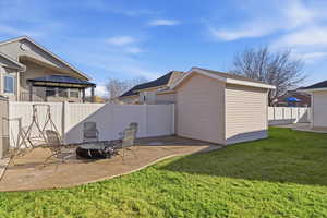 Fenced backyard featuring a gazebo, an outdoor fire pit area, a patio area, and a storage shed