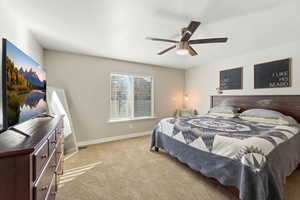 Carpeted bedroom with baseboards and ceiling fan