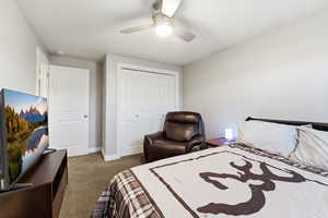 Carpeted bedroom with a closet and ceiling fan
