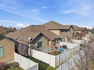 Rear view of house with a fenced backyard and a shingled roof