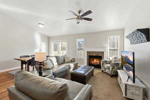 Living room with a tile fireplace and a ceiling fan