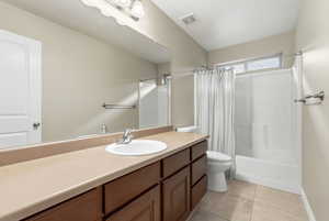 Bathroom with vanity, shower / bath combo with shower curtain, and light tile patterned floors