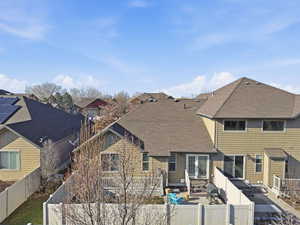 Back of property featuring roof with shingles, a fenced backyard, a residential view, and a patio