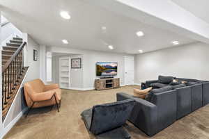 Living area featuring recessed lighting, light carpet, built in features, and a textured ceiling