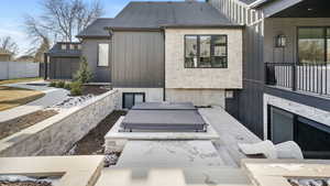Back of property featuring a shingled roof and a patio area