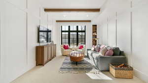 Living room featuring a decorative wall, beamed ceiling, carpet, and recessed lighting