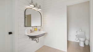 Bathroom featuring wood finished floors and wood walls