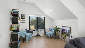 Sitting room featuring light wood finished floors, lofted ceiling, and recessed lighting