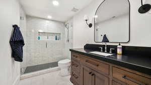 Bathroom featuring vanity, a stall shower, recessed lighting, and light tile patterned flooring
