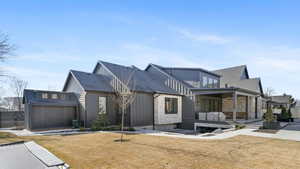 View of property exterior featuring a patio, board and batten siding, and a shingled roof
