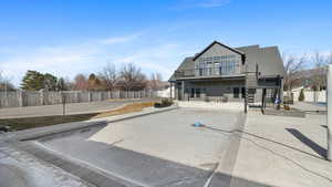 Back of property featuring a patio, a balcony, and board and batten siding