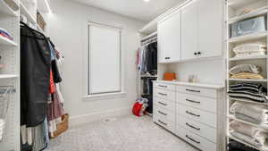 Walk in closet featuring light carpet