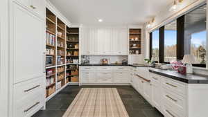 Kitchen featuring dark countertops, white cabinetry, open shelves, recessed lighting, and decorative backsplash
