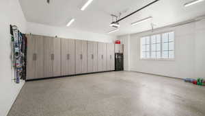 Garage featuring baseboards and a garage door opener