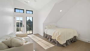 Bedroom with vaulted ceiling, wood finished floors, access to exterior, recessed lighting, and a ceiling fan