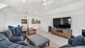 Living room featuring a ceiling fan, recessed lighting, carpet flooring, and lofted ceiling