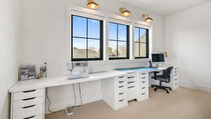 Office area with light colored carpet and built in desk