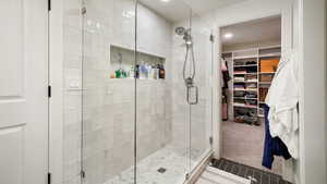 Full bathroom featuring a stall shower, a spacious closet, carpet, recessed lighting, and tile patterned floors