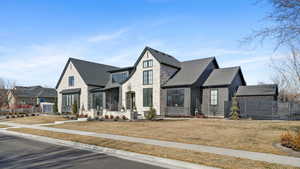 View of front of home with stone siding and a shingled roof